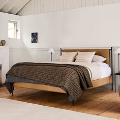 a bed sitting on top of a wooden floor next to a fire place