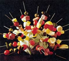 a bunch of skewers filled with different kinds of fruits and veggies