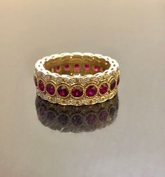 DeKara Designs Collection Metal- 18K Yellow Gold, .750. Stones- 20 Genuine Round Rubies 2.40 Carats, 120 Round Diamonds F-G Color VS1 Clarity 0.55 Carats. Entirely Handmade 18K Yellow Gold Eternity Diamond Round Ruby Engagement Band. This band is extremely elegant featuring beautiful and fiery rubies that are all professionally burnish set individually with amazing bead work surrounding each stone. There are 60 professionally pave set round diamonds on the top and bottom of band, which gives the Yellow Gold Halo Ruby Ring For Wedding, Elegant Hand-set Ruby Ring For Wedding, Elegant Wedding Ruby Ring Hand Set, Elegant Hand Set Ruby Ring For Wedding, Regal Yellow Gold Wedding Jewelry, Wedding Ruby Eternity Band In Fine Jewelry Style, Luxury Ruby Ring With Pave Setting For Wedding, Wedding Ruby Eternity Band In Yellow Gold, Classic Ruby Eternity Band For Wedding