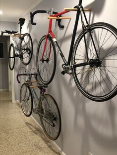 there are two bikes hanging on the wall and one has a bike mounted to it's side