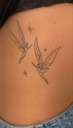 the back of a woman's stomach with two hummings on it and stars in the background