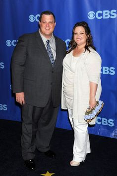 a man and woman standing next to each other in front of a blue wall with the abc's logo on it