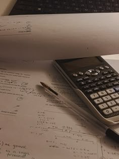 a calculator sitting on top of paper next to a pen