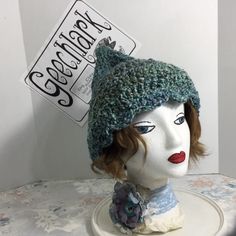 a mannequin head wearing a knitted hat with a tag on it's ear