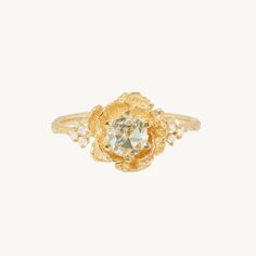 a yellow gold ring with an aqua blue topazte surrounded by small white pearls