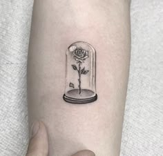 a rose in a glass dome tattoo on the right arm and leg, it is black and white