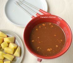 a red bowl filled with soup next to some cut up potatoes