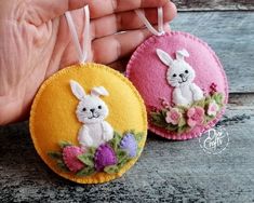 two handmade ornaments are shown in the shape of bunnies with flowers on them