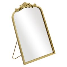 a mirror that is sitting on top of a metal stand with an ornate design around the edge