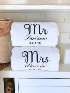 two personalized towels sitting on top of a shelf