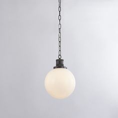 a white light hanging from a chain in a room