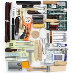 an assortment of crafting tools laid out on a white surface