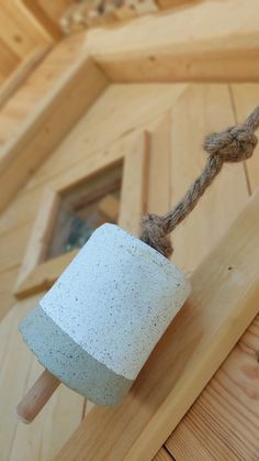 a white toilet paper roll on top of a wooden floor next to a rope and window