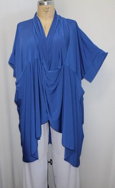 The perfect top for layering, done in a Royal Blue polyester spandex Traveler Knit One Size Fits 1X,2X,3X,4X Bust, Side seam to side seam: 72" total Length at center front:37" Length at sides: 49" Hips: 76" This unique tunic, has lots of detailing. Cross over draped front with soft roll collar, and tulip hem, with front insert pockets and long sleeves.. Fits a range of sizes.  Shown with the white wide leg pant, sold in a separate listing in my shop.  ONE SIZE, Made in  Los Angeles, California Blue V-neck Top, Blue V-neck Blouse For Layering, Blue One Size V-neck Top, Blue V-neck Top One Size, Blue Short Sleeve Lagenlook Top, Blue Lagenlook Short Sleeve Tops, Blue Lagenlook Top With Short Sleeves, Lagenlook Blue Short Sleeve Top, Blue Tunic For Spring, Free Size