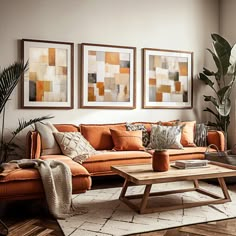 a living room with orange couches and paintings on the wall above them, along with a coffee table