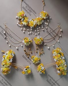 several pieces of jewelry with flowers and pearls on them are laid out on a table