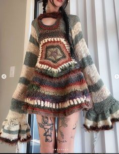 a woman with tattoos wearing a multicolored knitted sweater and matching tights