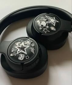 two black headphones with skulls and stars on the headsets are sitting next to each other