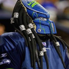 a close up of a person with dreadlocks on their head wearing a blue shirt