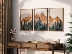 three paintings hang on the wall above a table with a plant in front of it