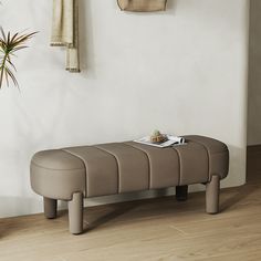 a bench sitting on top of a hard wood floor next to a potted plant