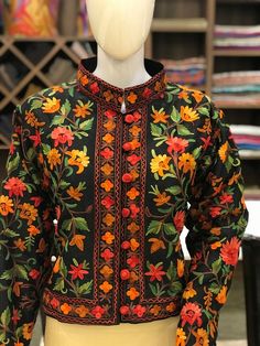 Suit up in Style with this Kashmiri bolero jacket. Product Details- Condition: Brand New (Made to order)- Fabric: Art Raw Silk - Base Color of Jacket: Black- Embroidery Color: Multi-Color Aari Embroidery- Fully Lined from Inside- Length: 20" (51 cms approx).- Care Instructions: Dry Clean Only.**If you want the jacket to be shorter or longer, just send us a message, and we will tailor it accordingly.**Colour customizations or change of fabric is also possible, just drop us a message.Sizing- Pleas Festive Long Sleeve Blazer For Fall, Embroidered Cotton Blazer With Long Sleeves, Embroidered Cotton Long Sleeve Blazer, Embroidered Long Sleeve Cotton Blazer, Embroidered Long-sleeve Cotton Blazer, Festive Black Spring Outerwear, Embroidered Fitted Nehru Jacket For Winter, Traditional Long Sleeve Winter Blazer, Fitted Outerwear With Floral Embroidery And Stand Collar