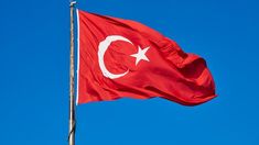 the flag of turkey is flying high in the blue sky with a white star on it