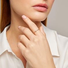 a woman wearing a diamond ring on her finger