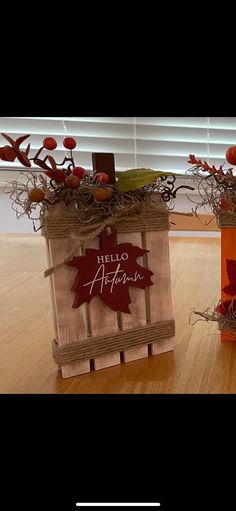 two bags with autumn decorations on them sitting on a wooden floor in front of a window