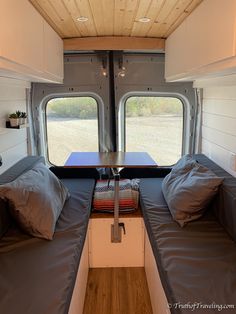 the inside of a camper with two beds and windows