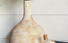 a vase with flowers in it sitting on a table next to a bowl and bottle