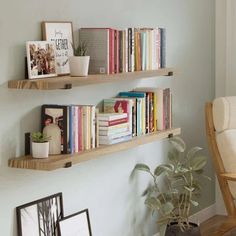 two wooden shelves filled with books next to a chair