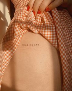 a woman's stomach with the words wild woman written on it and an orange gingham dress