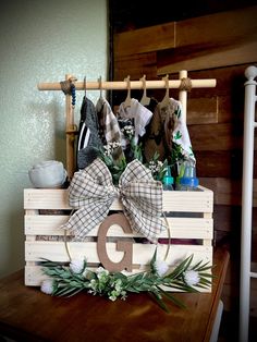 a wooden crate with clothes hanging from it's sides and a monogrammed g on the front