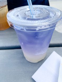 a plastic cup with a straw in it sitting on a table