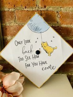 a graduation cap with winnie the pooh on it that says, only look back too see how far you have come