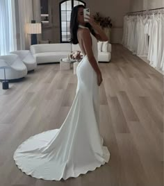 a woman in a white wedding dress taking a selfie