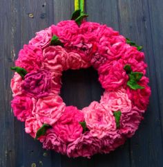 a pink wreath with green leaves and flowers