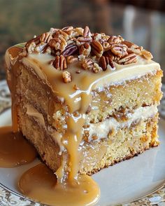 a piece of cake on a plate with caramel drizzle and pecans