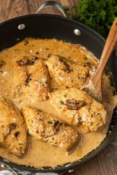 chicken with gravy in a skillet on a wooden table