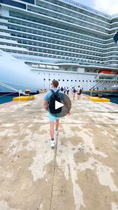 a person with a backpack walking towards a cruise ship