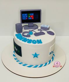 a white cake with blue and purple decorations on the top is decorated like a computer