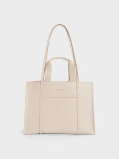 If you have an affinity for neutrals, the Shalia bag is a must-have addition to your collection. With its double top handles and versatile strap, this gem offers multiple styling options. The soft beige shade adds an aesthetically pleasing touch, making you look chic and polished from every angle while effortlessly complementing any ensemble you choose. For a simple yet elegant look, pair it with a pencil skirt and printed blouse combination. Tote Bag For Work, Edgy Bags, Bag Photography, Adjustable Bag Strap, Bags Ideas, Buy Bags, Adjustable Bag, Work Tote, Size Chart For Kids