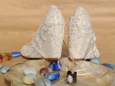 two white wedding shoes sitting on top of a plate next to glass beads and candy