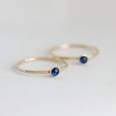 Tiny skinny stackable ring with beautiful deep blue Sapphire stone. It is made with a skinny but sturdy band, which allows you to create beautiful stacking sets! The ring is ideal for everyday wear and it will also look amazing with a festive dress. The ring is 0,8-0,9 mm thick and looks very dainty on the finger. Choose the finish of the stone (smooth cabochon or rose cut) and material for the ring (sterling silver or 9k gold). If you want to change the ring band design or get a custom ring or Tiny Sapphire Ring, Blue Gemstone Dainty Stackable Rings, Minimalist Sapphire Ring With Bezel Setting For Everyday, Dainty Blue Gemstone Stackable Rings, Everyday Stackable Sapphire Ring, Adjustable Gemstone Stackable Rings, Adjustable Stackable Birthstone Rings For Everyday, Adjustable Stackable Moonstone Ring For Everyday, Everyday Adjustable Stackable Birthstone Ring