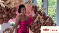 a woman in a pink dress standing next to balloons