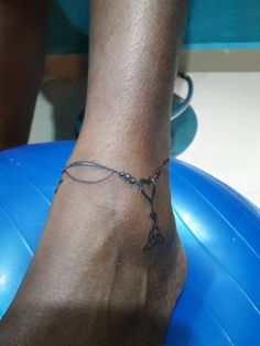 a person's foot with a tattoo on it and a ball in the background