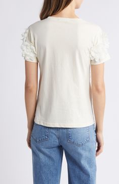 Dramatic flower appliqués add textural elegance to this lightweight and soft stretch-cotton top. Crewneck Short sleeves 60% rayon, 40% cotton Hand wash, line dry Made in the USA Chic Cream Tops With Floral Embroidery, Feminine Off White Cotton Top, Cream Cotton Top With Floral Embroidery, Elegant Off White Cotton Top, Spring Cotton Cream Tops, Spring Cream Cotton Tops, Elegant Cotton T-shirt For Spring, Chic Off-white Cotton Tops, White Tops With Floral Applique