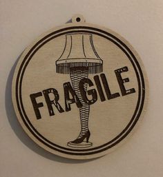 a round wooden ornament with the word fragile on it and a lampshade