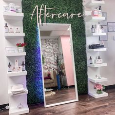 a mirror sitting on top of a wooden floor in front of a wall covered in plants